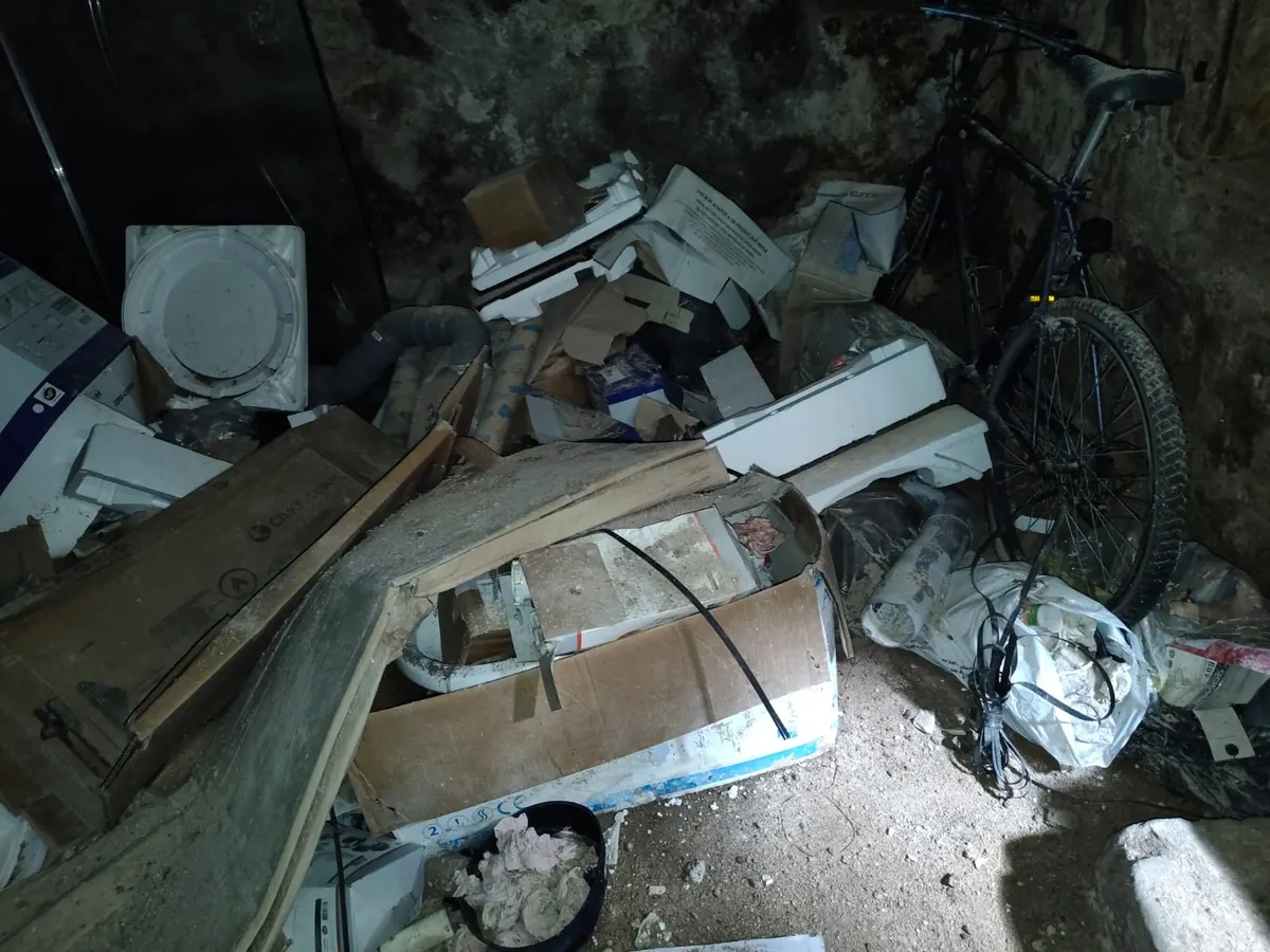 Cave voûtée remplie d’emballages et de déchets de chantier avant évacuation