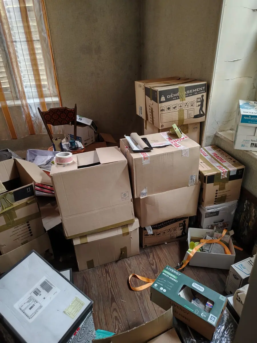 Pièce du logement squatté encombrée de cartons avant évacuation